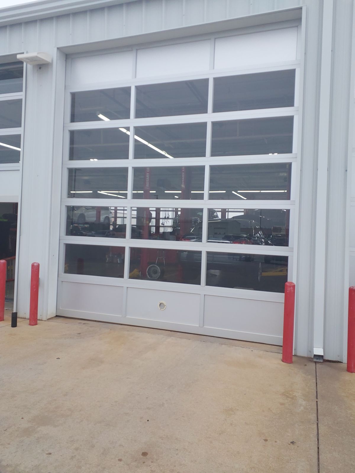 Full-view commercial door with bollards at a Lawton business