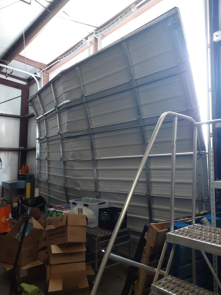 Badly damaged commercial garage door before emergency repair