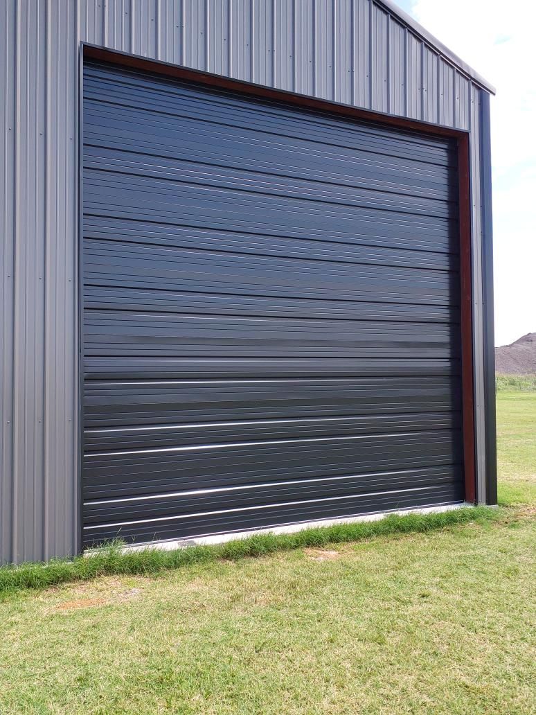 New black roll-up door installed on a metal building