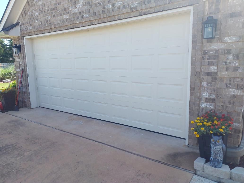 Completed double garage door replacement on a brick home in Lawton
