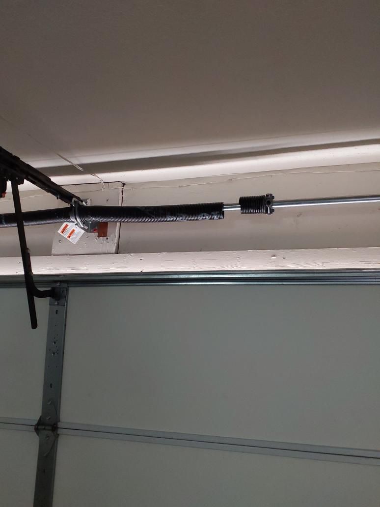 Broken garage door torsion spring above a residential door